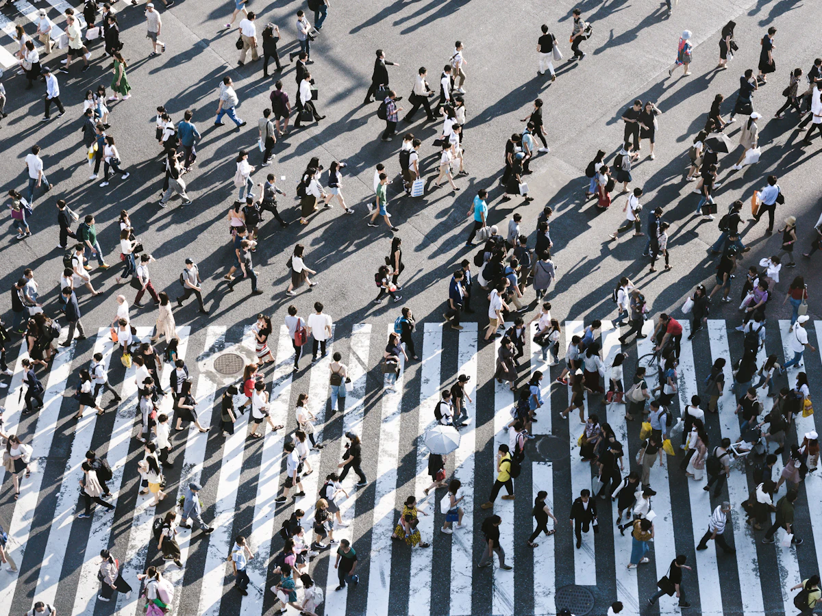 Tłum ludzi przechodzących przez skrzyżowanie Shibuya